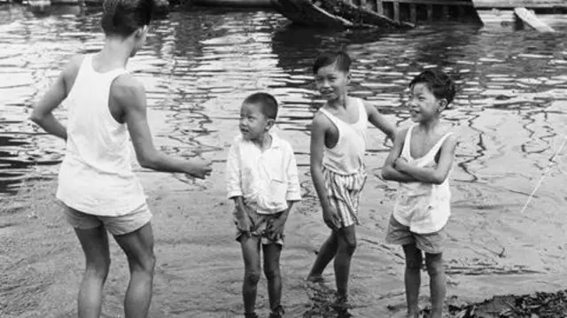 Watoto wa Singapore wanacheza karibu na bandari mapema miaka ya 1960. Nchi ilipozidi kuwa tajiri, watoto walianza kutumia wakati mwingi ndani ya nyumba