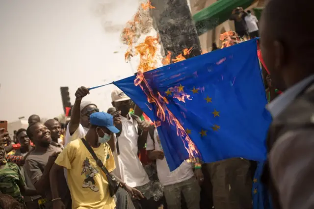 Manifestants brûlant le drapeau de l'Union européenne
