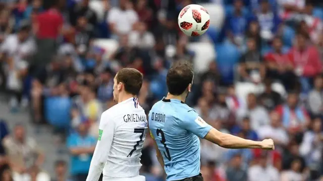 Antoine Griezmann disputa un balón con Diego Godín