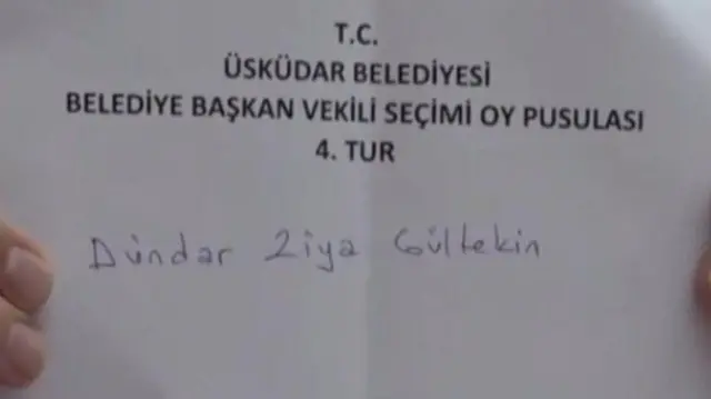 Beyaz bir kağıt. Üzerinde siyah renkle ve bilgisayar fontuyla T.C. Üsküdar Belediyesi Belediye Başkan Vekili Seçimi Oy Pusulası 4. Tur yazıyor. Altında mavi kalemle el yazısıyla Dündar Ziya Gültekin yazıyor.