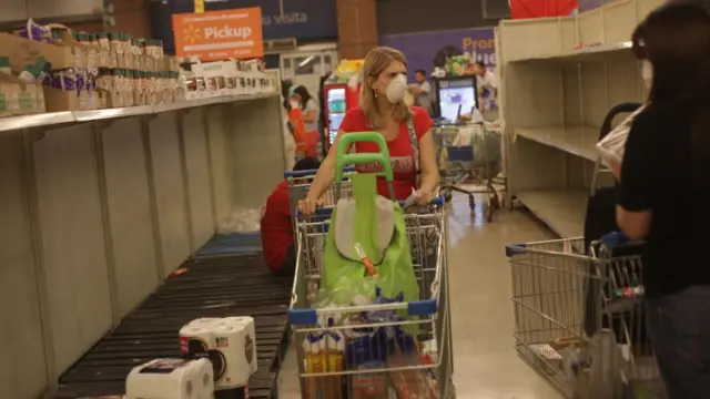 Una mujer en Chile pasea por los estantes vacíos de un supermercado