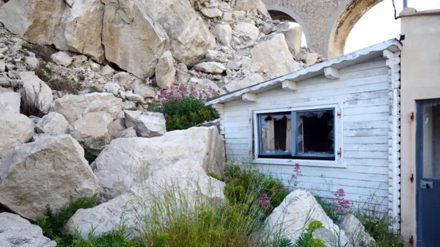 Damaged white house after a rock fall