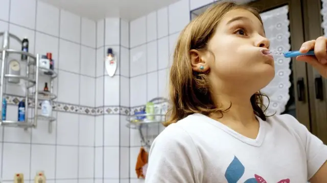 طفلة تستخدم فرشاة أسنان