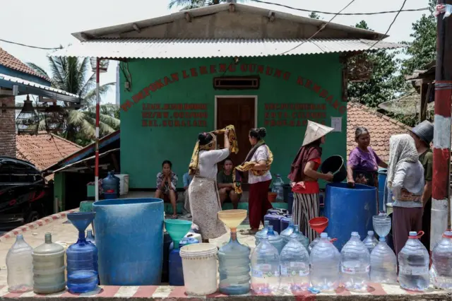 Para perempuan menunggu untuk mengisi ember mereka dengan air dari tangki air karena kekeringan di Desa Suralaya, Banten, pada 14 September 2023.
