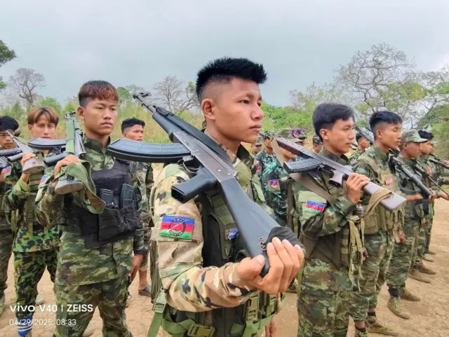 သေနတ်ထမ်းပြီး တန်းစီရပ်နေကြတဲ့ စစ်ဝတ်စုံပြည့်နဲ့ ချင်းတပ်ဖွဲ့ဝင်လူငယ်တွေ 