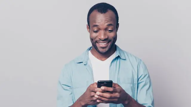 Jovem segurando o celular, sorrindo