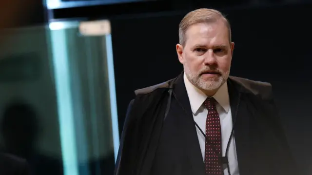 Ministro José Antonio Dias Tofolli usando a toga e caminhando.