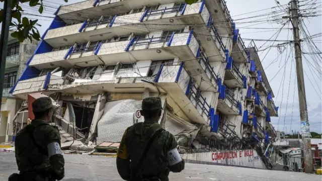 Soldados vigilan un edificio derrumbado