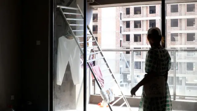 Bà Xu, người mua nhà đang đứng tại căn hộ chưa hoàn thiện mà cô đang sống. Bức ảnh chụp màn hình này được lấy từ một đoạn phim ngày 17 tháng 9 năm 2022