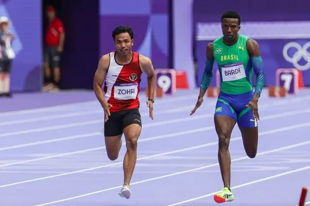 Pelari putra Indonesia Lalu Muhammad Zohri (kiri) memacu kecepatan pada round I nomor 100 meter putra Olimpiade Paris 2024 di Stade de France, Paris, Prancis, Sabtu (3/8/2024).