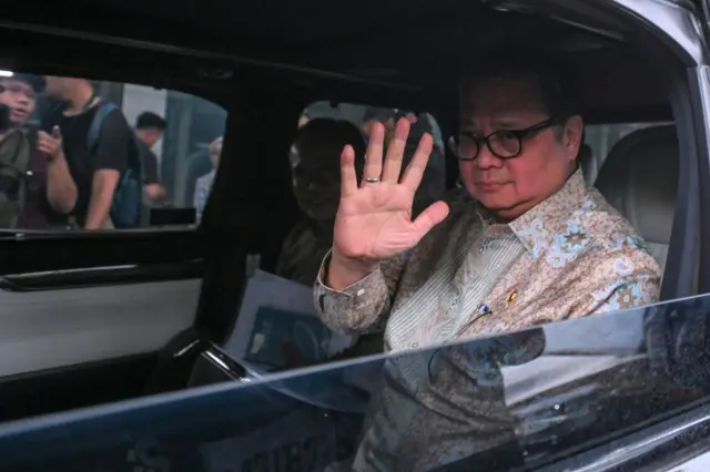 Menko Perekonomian Airlangga Hartarto melambaikan tangannya di dalam mobil usai membahas kajian pencegahan korupsi di Gedung Merah Putih KPK, Jakarta, Rabu (14/1/2026)