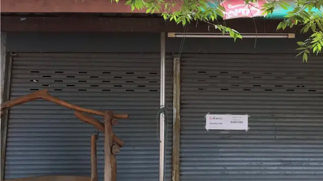 ป้ายปิดชั่วคราวถูกแปะไว้บนประตูเหล็กหน้าร้านนวดของพัชรี