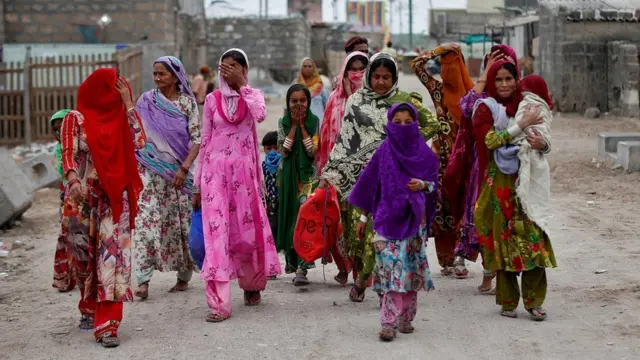 गुजरात के वेरावल में तूफ़ान से बचने के लिए सुरक्षित स्थानों पर जाते लोग