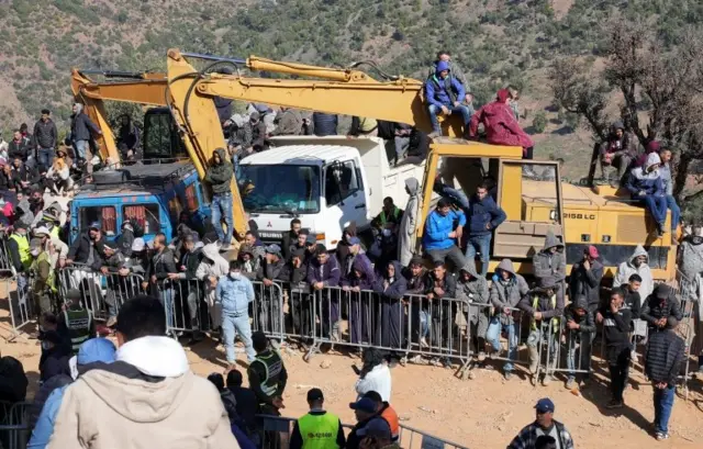 الناس يتجمعون بينما يعمل رجال الإنقاذ للوصول إلى ريان العالق في البئر