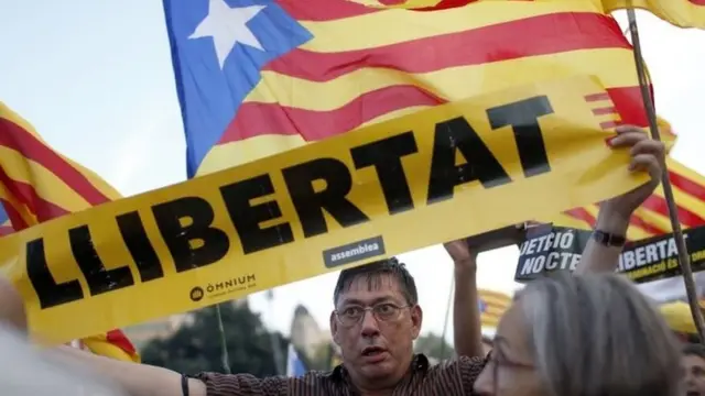A protester in Barcelona holds a banner demanding freedom for 12 Catalan leaders on trial. Photo: 1 October 2019