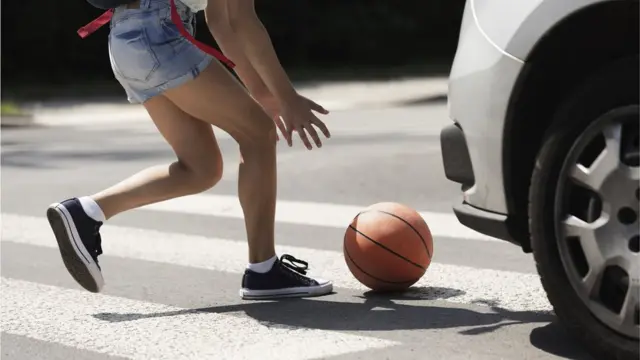 Баскетбольный мяч под колесами автомобиля
