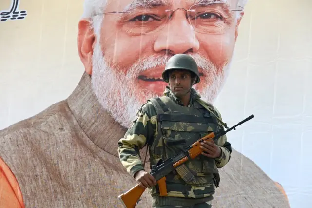 નરેન્દ્ર મોદીના પોસ્ટર પાસે ઉભેલા સૈનિકનો ફોટોગ્રાફ