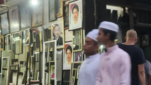 একটি দোকানে জিয়াউর রহমান ও খালেদা জিয়ার ছবি টাঙানো। 