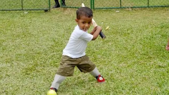  කාඩ්බෝඩ් වලින් සාදා දුන් පා ආවරණ යුගලයක් පැළඳ ක්‍රිකට් ක්‍රීඩාවේ යෙදෙන කුඩා ශරුජන් 