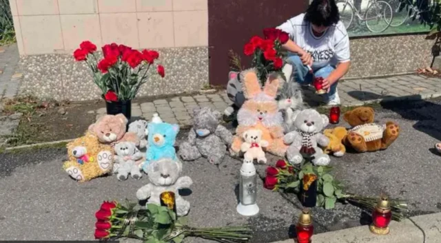 Люди несуть квіти та іграшки до меморіалу вбитим хлопцям