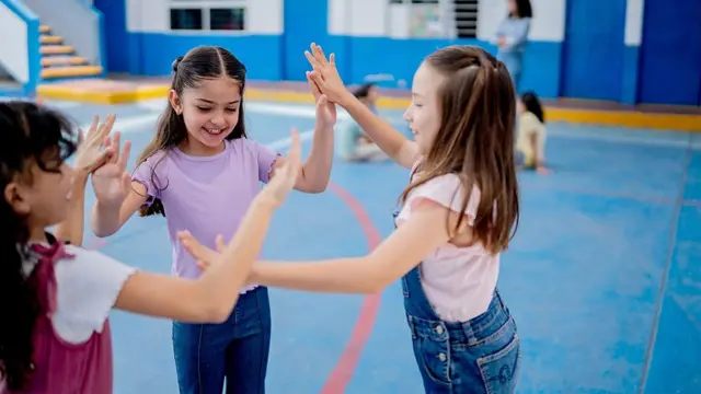 Meninas brincando dentro de um ginásio.