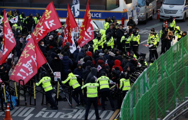 Les partisans et les détracteurs de Yoon devant sa résidence, mercredi