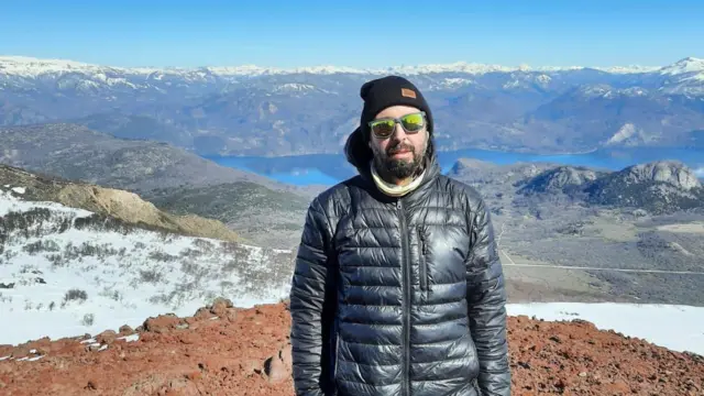Hombre con gafas de sol y casaca en una montaña en la Patagonia argentina.