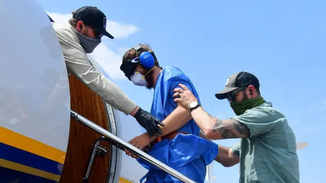 L'un des Américains emprisonnés monte à bord d'un avion à l'aéroport de Kinshasa.