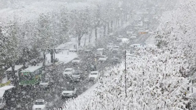 ソウル南部で雪に覆われた道路を走行する車両