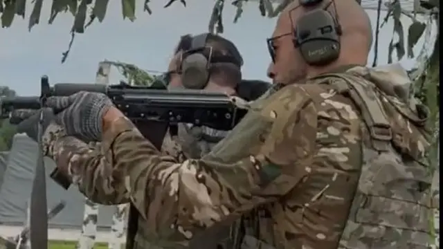 Ендрю Тейт стріляє з автомата.