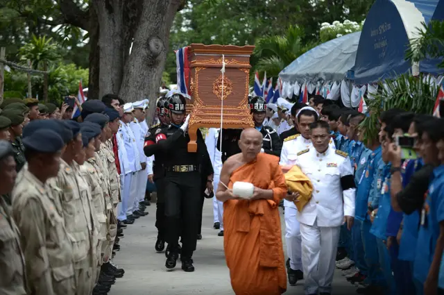 เจ้าหน้าที่แบกโลงบรรจุร่าง จ.อ. สมาน มายังบริเวณศาลาวัดเพื่อประกอบพิธี