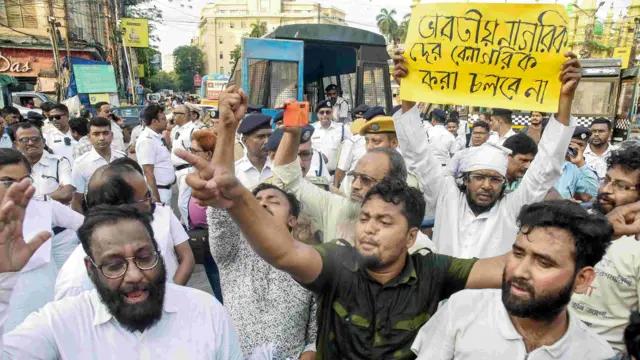 এসআইআর বিরোধী বিক্ষোভে পশ্চিমবঙ্গের মানুষ রাস্তায় প্রতিবাদ কর্মসূচি পালন করছেন। একজন বিক্ষোভকারীর হাতে ব্যানারে লেখা, “ভারতের নাগরিকদের বেনাগরিক করা চলবে না।”