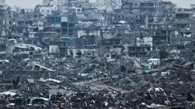 فلسطینی‌ها در حال قدم زدن درمیان ویرانه‌های باقیمانده از جنگ در غزه 