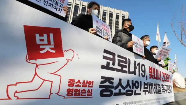 코로나피해단체연대 등 중소상인 단체 회원들이 18일 서울 정부청사 앞에서 코로나19의 피해로 인한 중소상인들의 부채 문제를 정부가 시급히 해결할 것을 촉구하고 있다