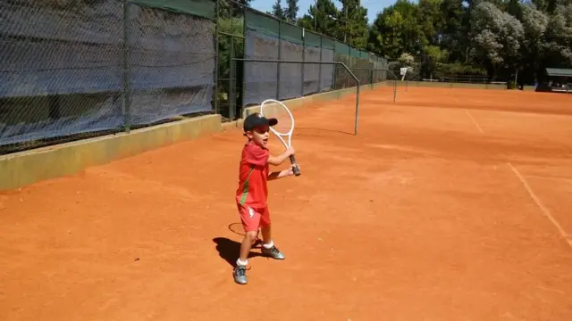 Niño jugando al tenis