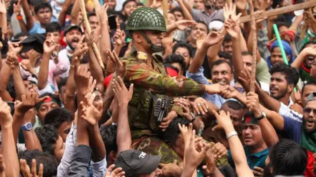 শেখ হাসিনার পালিয়ে যাবার খবরে মাঠ পর্যায়ের সৈনিকদের ঘিরে উল্লাস করেন সাধারণ মানুষ।