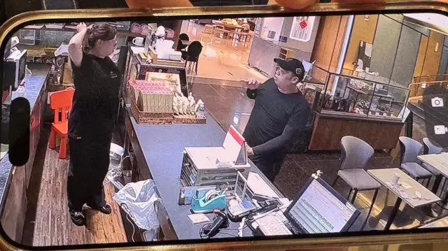 身穿黑衣嫌犯(右)7月6日在饭店施袭前在餐厅购买咖啡,被监视器录下。