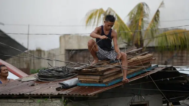 Un filipino en Tuguegarao, capital de Cagayan, reforzando su casa ante la llegada el tifón Mangkhut.
