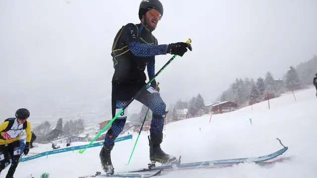 Никита Филиппов бежит на лыжах по склону горы