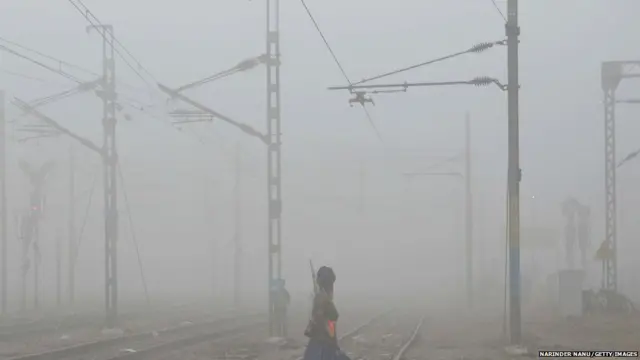 A MAN crosses railway tracks amidst dense smog near Amritsar railway station on November 7, 2017