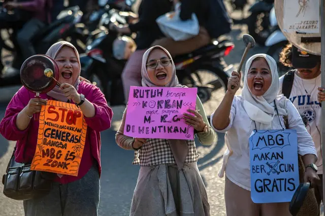 Para perempuan beradu alat makan dalam aksi unjuk rasa menuntut diakhirinya program makanan gratis dari pemerintah setelah insiden keracunan makanan baru-baru ini, di Sleman, Yogyakarta, pada 26 September 2025.