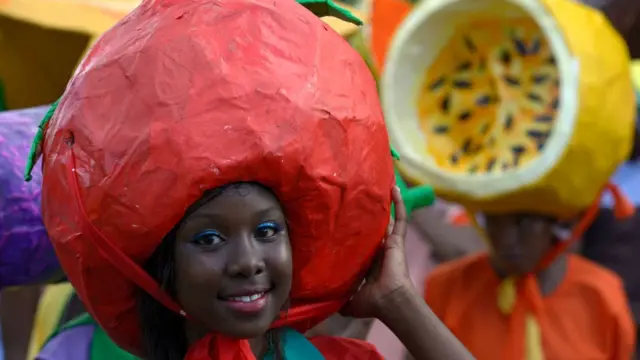 Girl wey carry big red headdress for head for Seychelles Carnival.