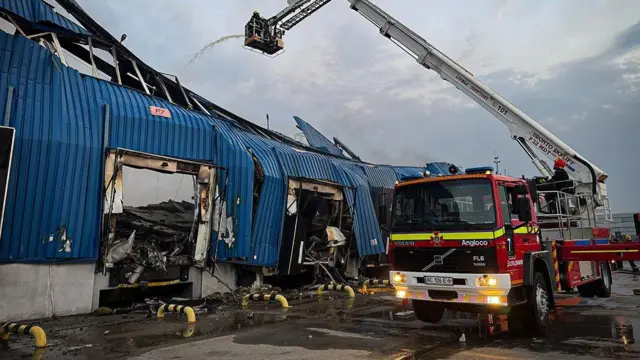 Пожежники гасять пожежу на складі з допомогою підйомного крана
