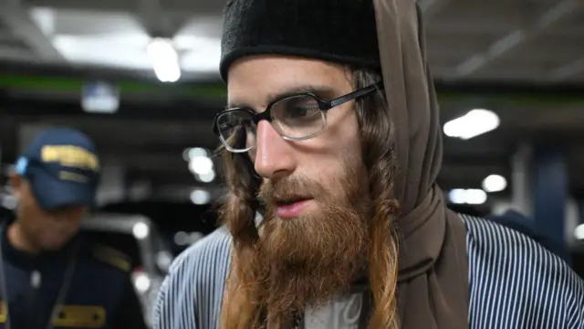 El ciudadano israelí Yoel Alter, de 35 años, miembro de la secta judía ultraortodoxa Lev Tahor, observa mientras es escoltado por agentes de policía guatemaltecos tras ser detenido en un tribunal de la ciudad de Guatemala el 24 de enero de 2025.