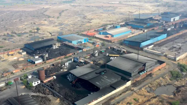 A drone shot of a cluster of pyrolysis plants against an arid landscape.