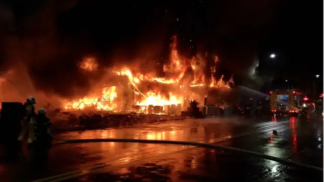Firefighters using water cannon to extinguish a fire on a commercial and residential building in Kaohsiung city, southern Taiwan, 14 October 2021