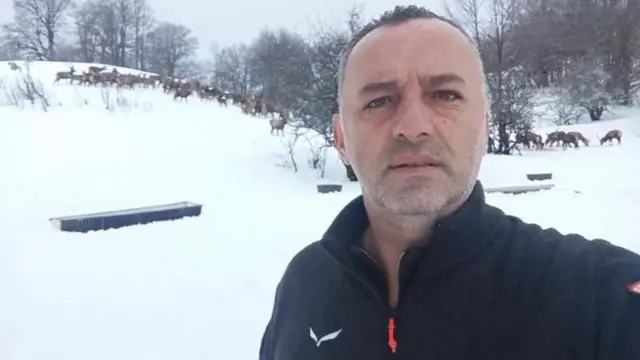 rendžer Laze u prvom planu, nosi crnu duksericu, u pozadini su jeleni i drveće bez lišća