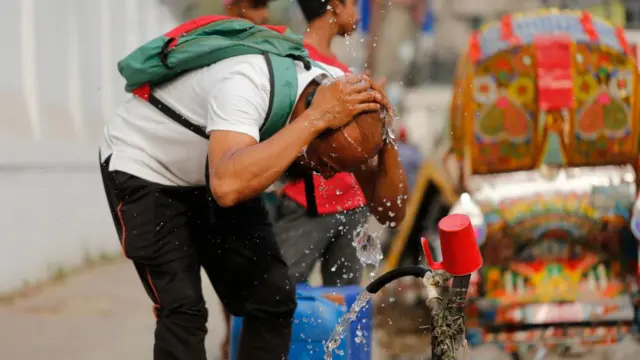 গরমে মাথায় পানি দিচ্ছেন রাস্তা দিয়ে যাওয়া এক ব্যক্তি