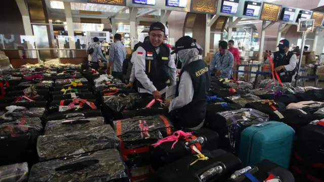 Sejumlah Petugas Panitia Penyelenggara Ibadah Haji (PPIH) Indonesia 1443 H/2022 merapihkan koper bawaannya di Terminal 3 Bandara Soekarno Hatta, Tangerang, Banten, Rabu (1/6/2022).