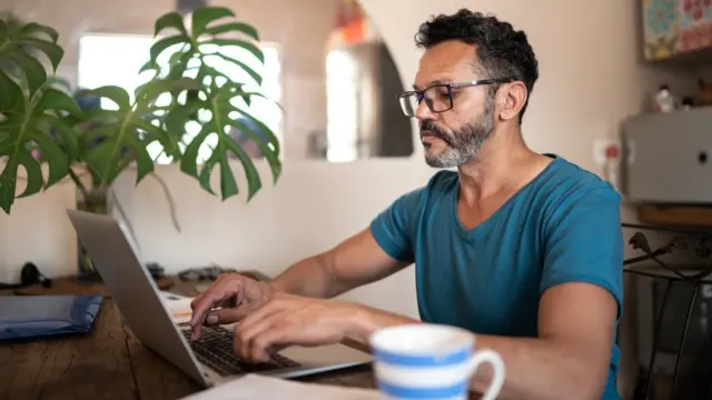 Homem usando laptop para trabalharjogo que aposta dinheirocasa